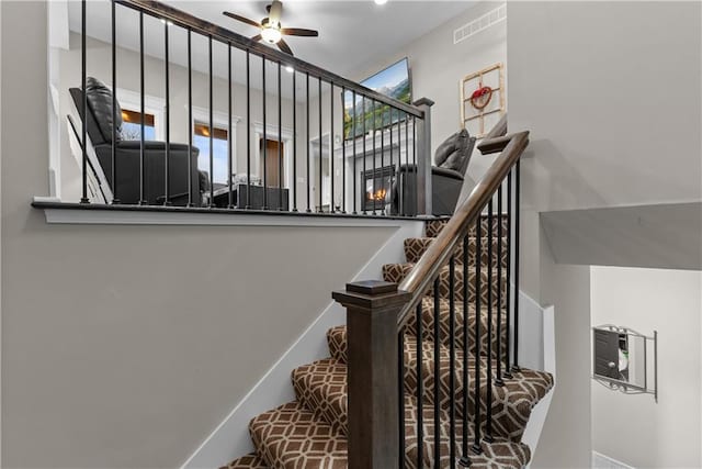 staircase featuring visible vents and ceiling fan