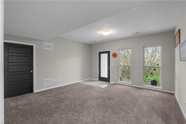 carpeted spare room with visible vents and baseboards