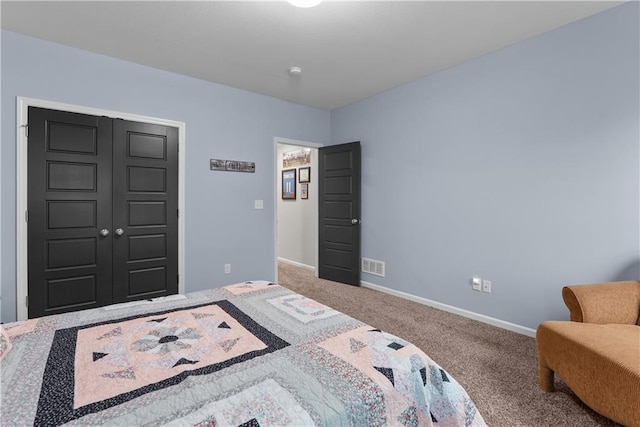 carpeted bedroom with a closet, baseboards, and visible vents