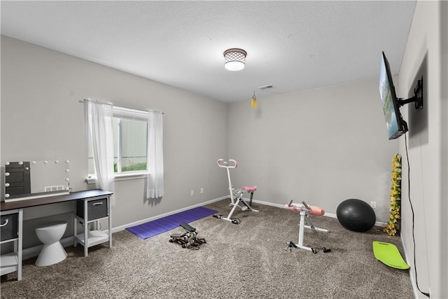 exercise room with a textured ceiling, baseboards, and visible vents