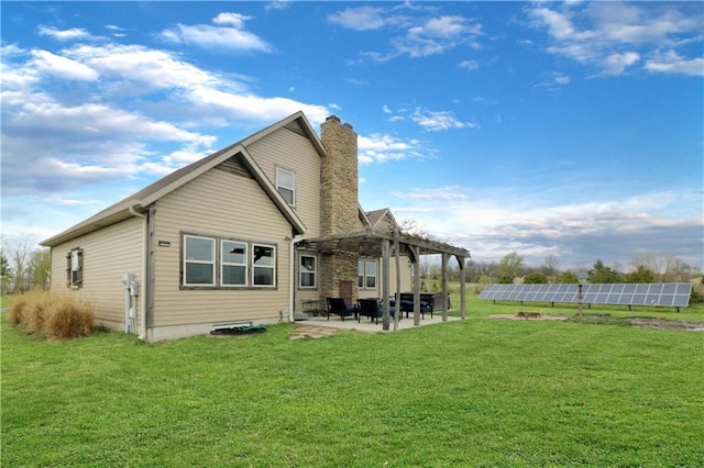 611 NW 1421st Rd, Holden, MO 64040 - rear view of property with solar panels, a chimney, a pergola, and a lawn