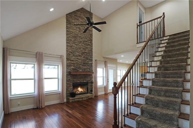 611 NW 1421st Rd, Holden, MO 64040 - unfurnished living room with hardwood / wood-style flooring, stairs, baseboards, high vaulted ceiling, and ceiling fan