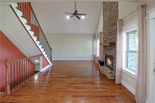 611 NW 1421st Rd, Holden, MO 64040 - unfurnished living room featuring a fireplace, high vaulted ceiling, ceiling fan, wood finished floors, and baseboards