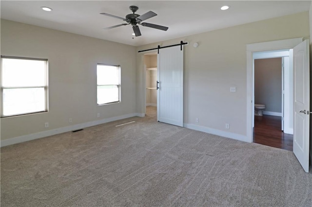 611 NW 1421st Rd, Holden, MO 64040 - unfurnished bedroom featuring a barn door, carpet, baseboards, recessed lighting, and ceiling fan