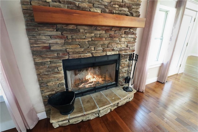 611 NW 1421st Rd, Holden, MO 64040 - detailed view of wood finished floors, a fireplace, and baseboards