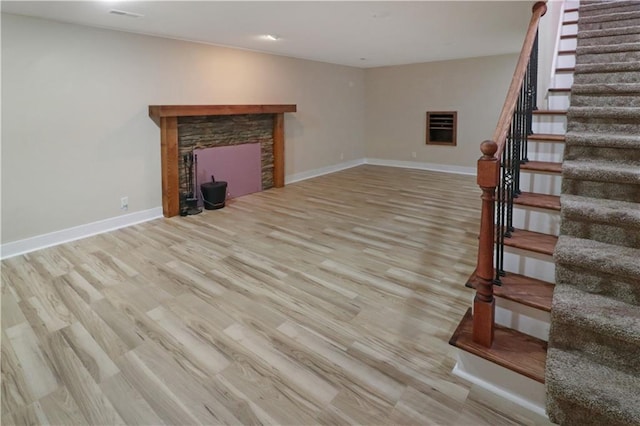 611 NW 1421st Rd, Holden, MO 64040 - unfurnished living room with wood finished floors, stairs, a stone fireplace, and baseboards