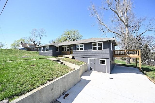 ranch-style home with driveway, a front yard, and a deck