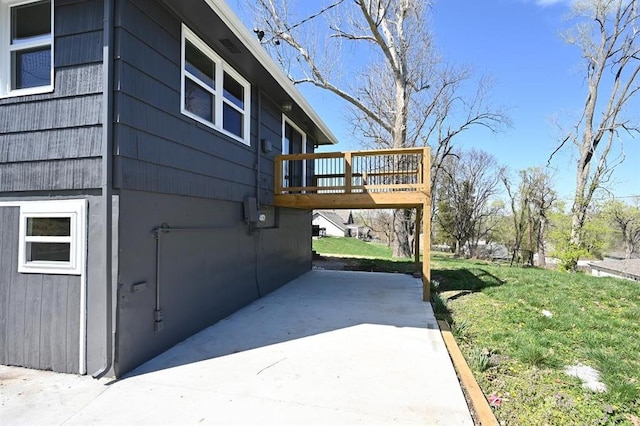 view of home's exterior with a wooden deck and a lawn