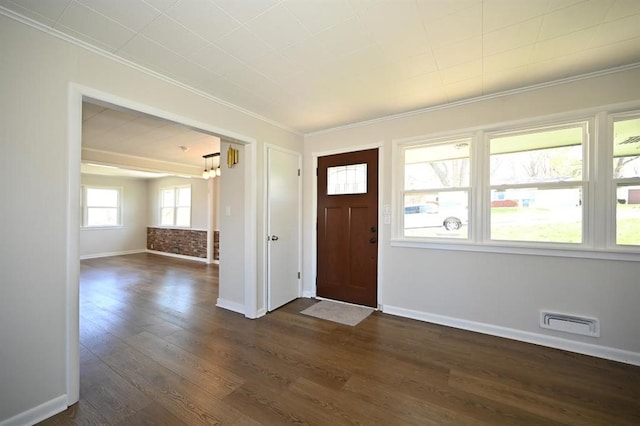 foyer featuring crown molding, dark wood-style flooring, baseboards, and visible vents