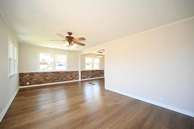 unfurnished room with crown molding, ceiling fan with notable chandelier, and dark wood-style floors