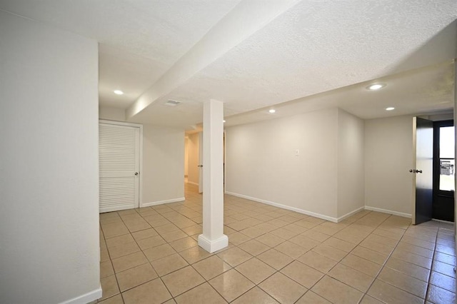 below grade area with recessed lighting, light tile patterned floors, and baseboards