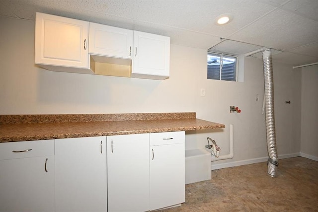 kitchen with baseboards and white cabinetry