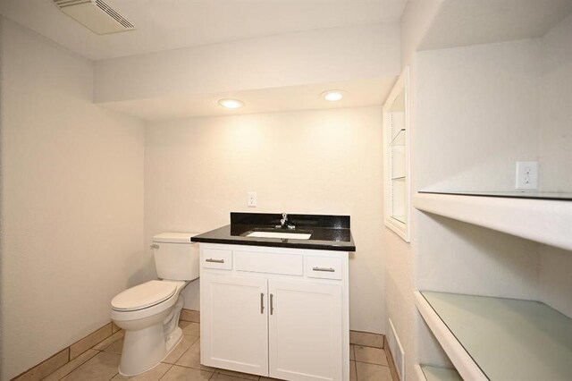 bathroom featuring visible vents, toilet, vanity, and tile patterned flooring