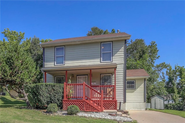 1610 E 37th St, Kansas City, MO 64109 - traditional-style house featuring stairway, a front lawn, an outdoor structure, a porch, and a storage unit