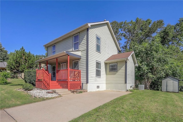 1610 E 37th St, Kansas City, MO 64109 - traditional-style house with a storage unit, an outbuilding, a front lawn, central AC, and covered porch