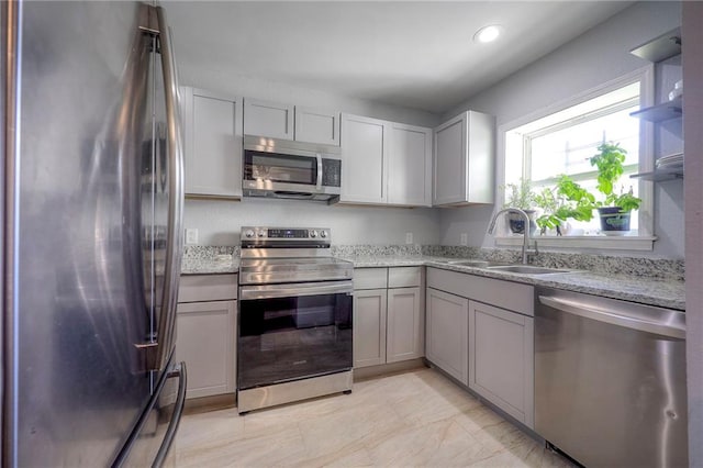 1610 E 37th St, Kansas City, MO 64109 - kitchen featuring recessed lighting, light stone counters, stainless steel appliances, open shelves, and a sink