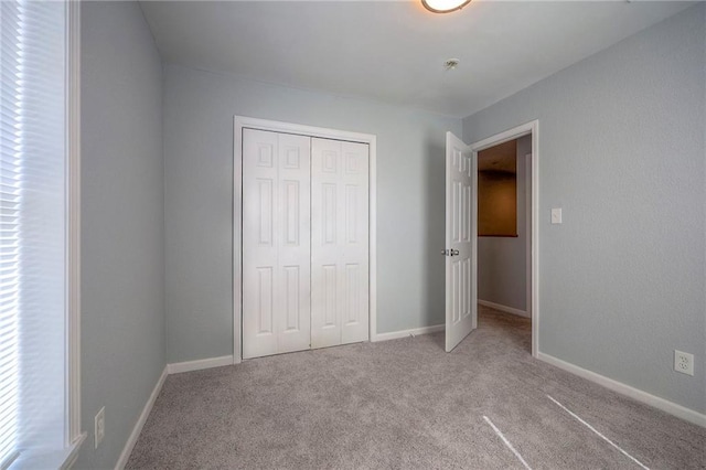 1610 E 37th St, Kansas City, MO 64109 - unfurnished bedroom featuring baseboards, carpet flooring, multiple windows, and a closet