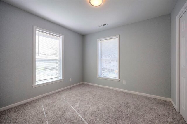1610 E 37th St, Kansas City, MO 64109 - carpeted empty room featuring baseboards, a healthy amount of sunlight, and visible vents