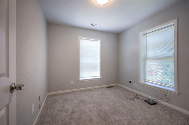 1610 E 37th St, Kansas City, MO 64109 - unfurnished room with baseboards, carpet flooring, visible vents, and plenty of natural light