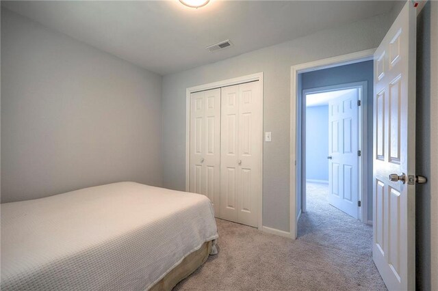1610 E 37th St, Kansas City, MO 64109 - bedroom with visible vents, baseboards, a closet, and light colored carpet