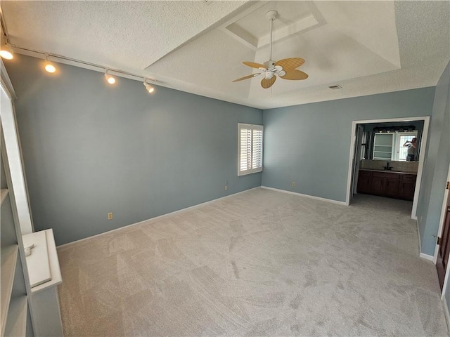 301 E Partridge Ave Unit K, Independence, MO 64055 - unfurnished bedroom with rail lighting, light colored carpet, baseboards, and a textured ceiling