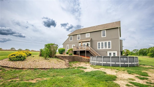 25477 Crestview Dr, Paola, KS 66071 - back of house with a wooden deck, stairway, an outdoor pool, and a yard