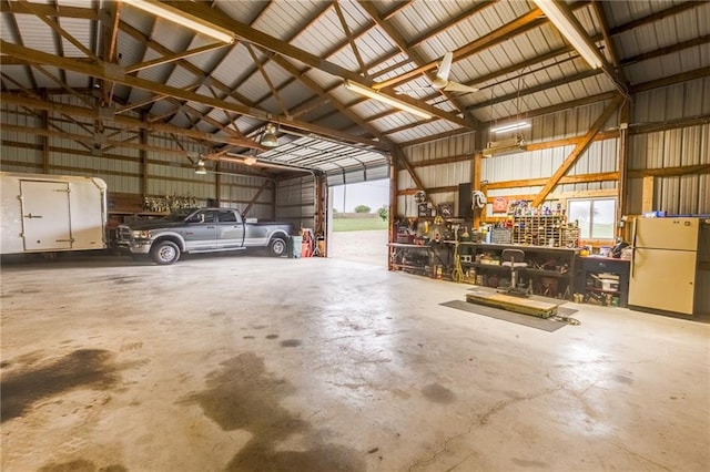 25477 Crestview Dr, Paola, KS 66071 - garage with freestanding refrigerator and a workshop area