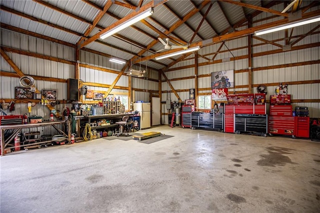 25477 Crestview Dr, Paola, KS 66071 - garage with a workshop area, freestanding refrigerator, and metal wall