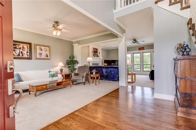25477 Crestview Dr, Paola, KS 66071 - living room featuring a ceiling fan, wood finished floors, a fireplace, crown molding, and baseboards