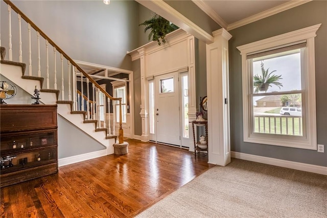 25477 Crestview Dr, Paola, KS 66071 - foyer entrance with ornamental molding, stairs, baseboards, ornate columns, and wood finished floors