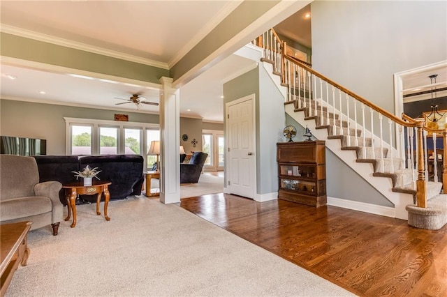 25477 Crestview Dr, Paola, KS 66071 - living room with crown molding, wood finished floors, stairs, ceiling fan, and recessed lighting