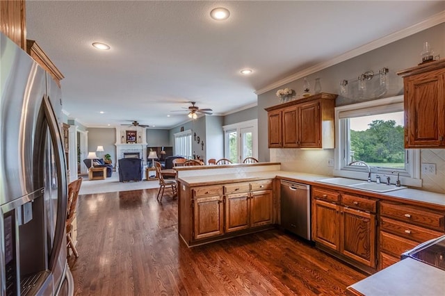 25477 Crestview Dr, Paola, KS 66071 - kitchen featuring appliances with stainless steel finishes, a sink, light countertops, a peninsula, and a fireplace