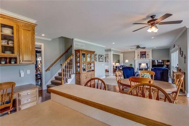 25477 Crestview Dr, Paola, KS 66071 - dining space featuring a ceiling fan, ornamental molding, a fireplace, stairs, and baseboards
