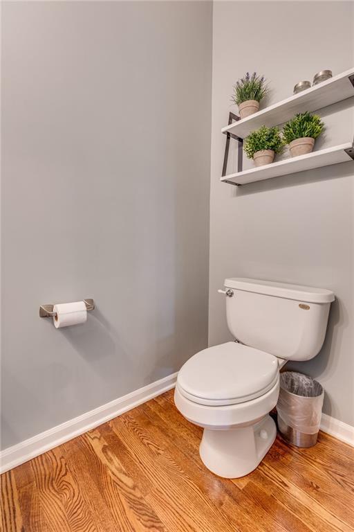 25477 Crestview Dr, Paola, KS 66071 - bathroom featuring baseboards, wood finished floors, and toilet