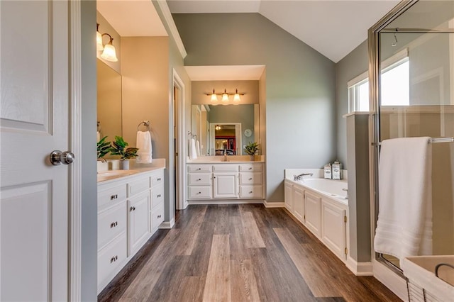 25477 Crestview Dr, Paola, KS 66071 - full bath with wood finished floors, lofted ceiling, a bath, two vanities, and a stall shower