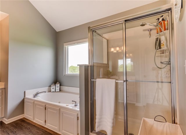 25477 Crestview Dr, Paola, KS 66071 - full bath featuring a whirlpool tub, a stall shower, vaulted ceiling, and wood finished floors