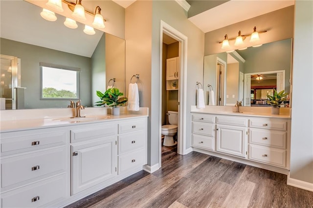25477 Crestview Dr, Paola, KS 66071 - full bath featuring wood finished floors, two vanities, toilet, and baseboards