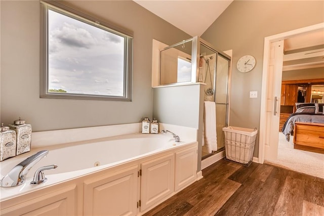 25477 Crestview Dr, Paola, KS 66071 - bathroom with wood finished floors, ensuite bath, a garden tub, and a stall shower