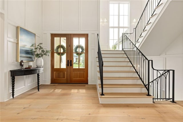 11316 W 170th Ter, Overland Park, KS 66221 - entryway featuring a decorative wall, french doors, stairs, light wood-style flooring, and a high ceiling