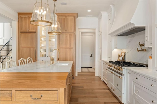 11316 W 170th Ter, Overland Park, KS 66221 - kitchen with custom exhaust hood, a sink, double oven range, light wood finished floors, and a chandelier