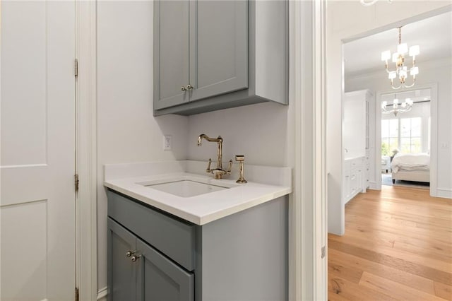 11316 W 170th Ter, Overland Park, KS 66221 - bathroom with a chandelier, vanity, wood finished floors, and crown molding