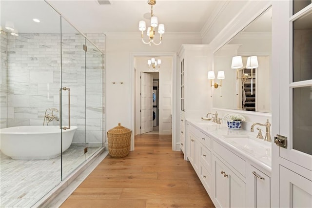 11316 W 170th Ter, Overland Park, KS 66221 - bathroom with a chandelier, a freestanding bath, double vanity, wood finished floors, and crown molding