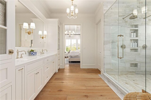 11316 W 170th Ter, Overland Park, KS 66221 - full bath featuring a chandelier, crown molding, double vanity, a stall shower, and wood finished floors