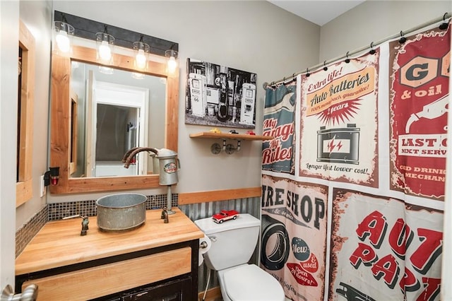 full bathroom with vanity, wainscoting, toilet, and a shower with shower curtain