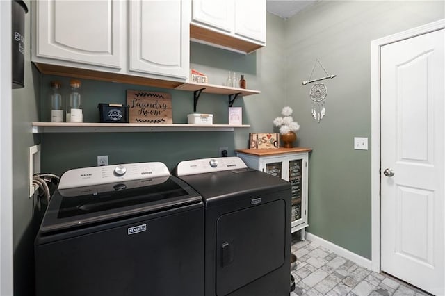 clothes washing area with cabinet space, washer and clothes dryer, and baseboards