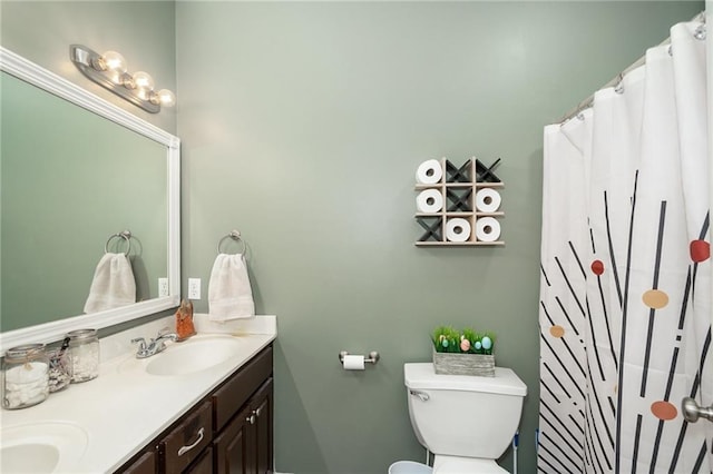 bathroom featuring toilet and double vanity