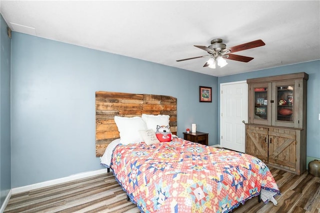 bedroom with wood finished floors, baseboards, and a ceiling fan