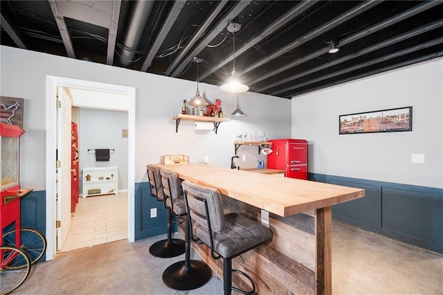 indoor wet bar featuring finished concrete flooring and pendant lighting