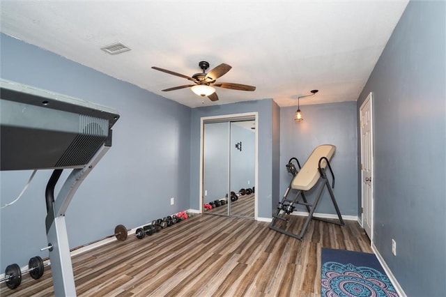 workout room featuring a ceiling fan, wood finished floors, and baseboards
