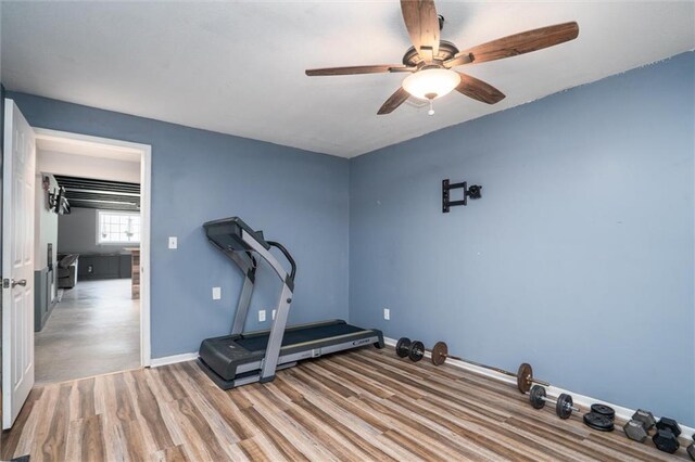 exercise room with ceiling fan, wood finished floors, and baseboards